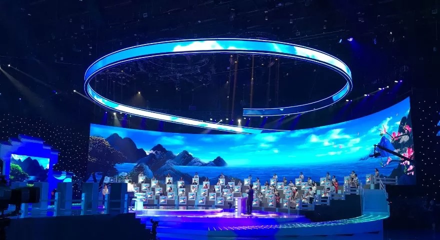 Concert stage with circular overhead LED ring and full audience lighting